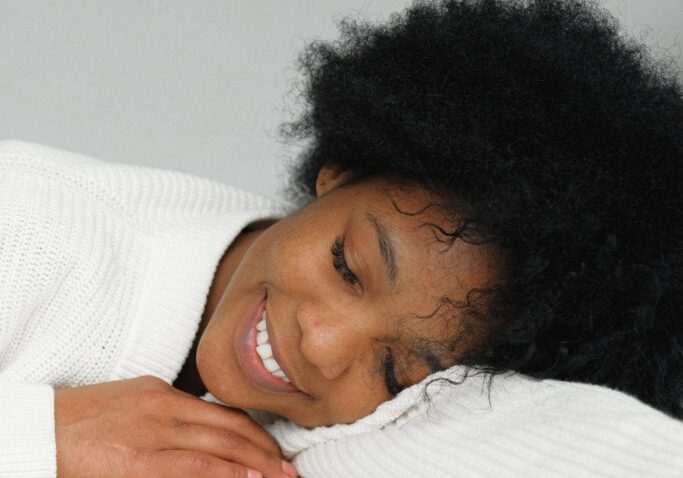 dreaming-charming-black-woman-leaning-on-table-3746281